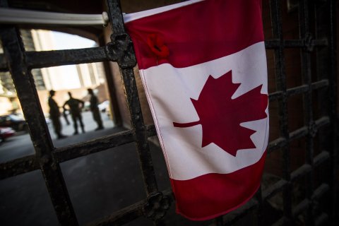 : Soldiers stand behind a Canadian flag at a makeshift memorial in honour of Cpl. Nathan Cirillo outside of The Lieutenant-Colonel John Weir Foote Armoury in Hamilton, October 23, 2014. A gunman attacked Canada's parliament on Wednesday, with gunfire erupti