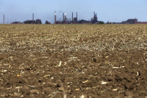 � Siphiwe Sibeko / Reuters: Chimneys from ArcelorMittal steel company are seen behind a dry maize field near Vanderbijlpark? outside Johannesburg, October 1 2015. Poor rains are forecast for South Africa's maize belt because of the El Nino weather pattern, expected to bring more dro