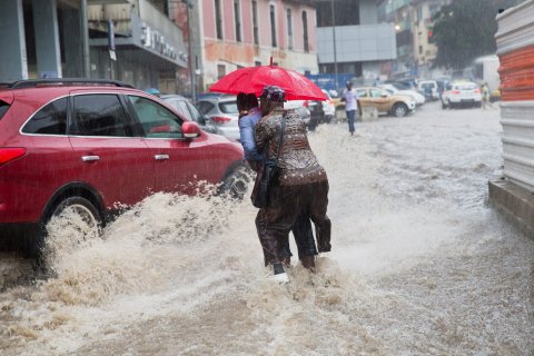 MICHAEL KAPPELER: epa04141711 A man carries another across a flooded street after heavy rainfalls in Luanda, Angola, 26 March 2014. It is the first heavy rain at the start of the rainy season. Germany Foreign�Minister Steinmeier is on a three-day trip to the West African c