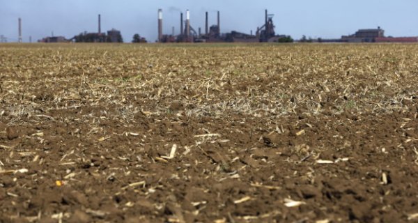 � Siphiwe Sibeko / Reuters: Chimneys from ArcelorMittal steel company are seen behind a dry maize field near Vanderbijlpark? outside Johannesburg, October 1 2015. Poor rains are forecast for South Africa's maize belt because of the El Nino weather pattern, expected to bring more dro