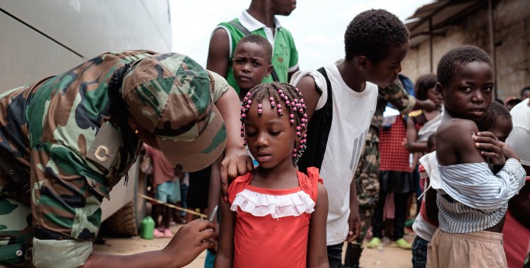 JOOST DE RAEYMAEKER: epaselect epa05164601 A Angolan military administers a yellow fever vaccine to a child at 'Quilometro 30' market, Luanda, Angola, 16 February 2016. This market in the Angolan capital was considered the center of the yellow fever outbreak killing 51 people